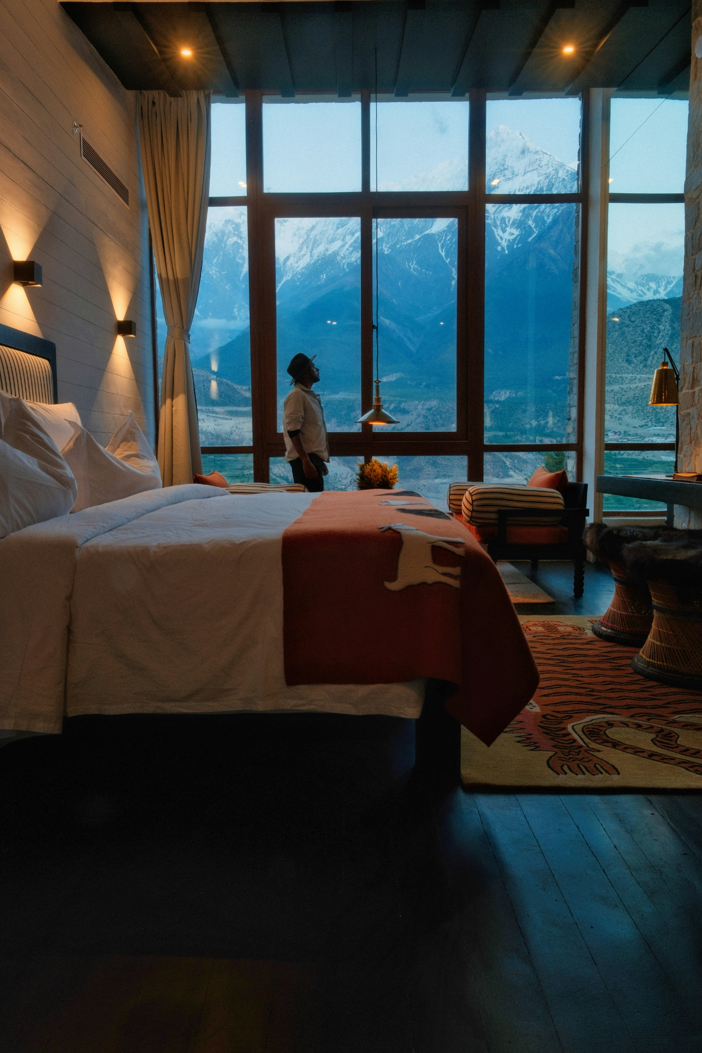 A hotel guest taking in snow-capped mountain views from a design-forward suite before heading out to explore